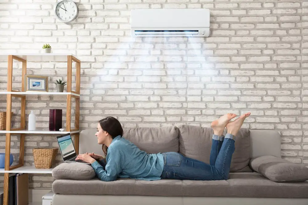 lady on couch enjoying air conditioner after aircon chemical wash service